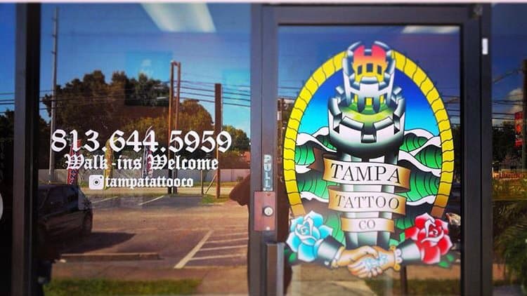 Tampa Tattoo Co. storefront window with ornate gold-framed mural art