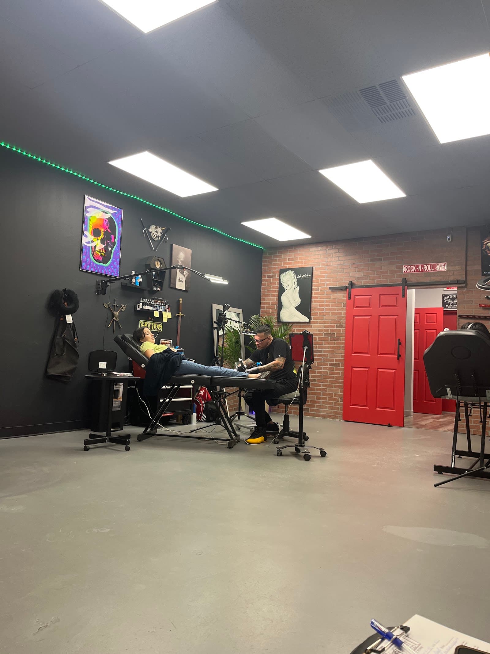 Inside Angry Raven Tattoo — dark walls, red doors, working stations
