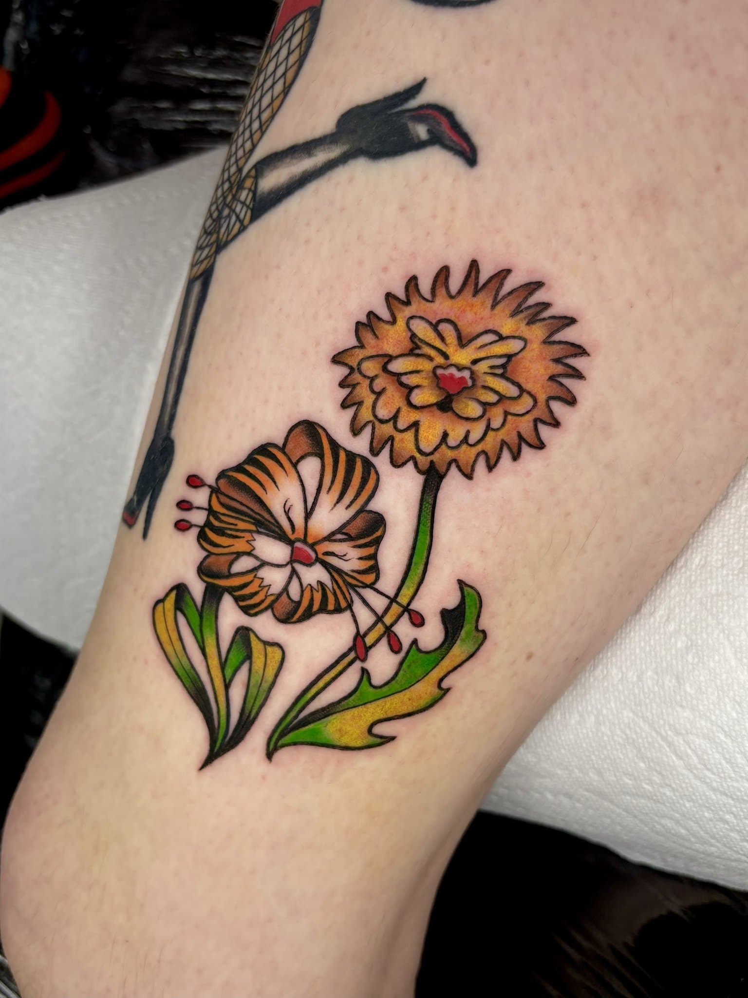 Color traditional flowers tattooed on an upper arm