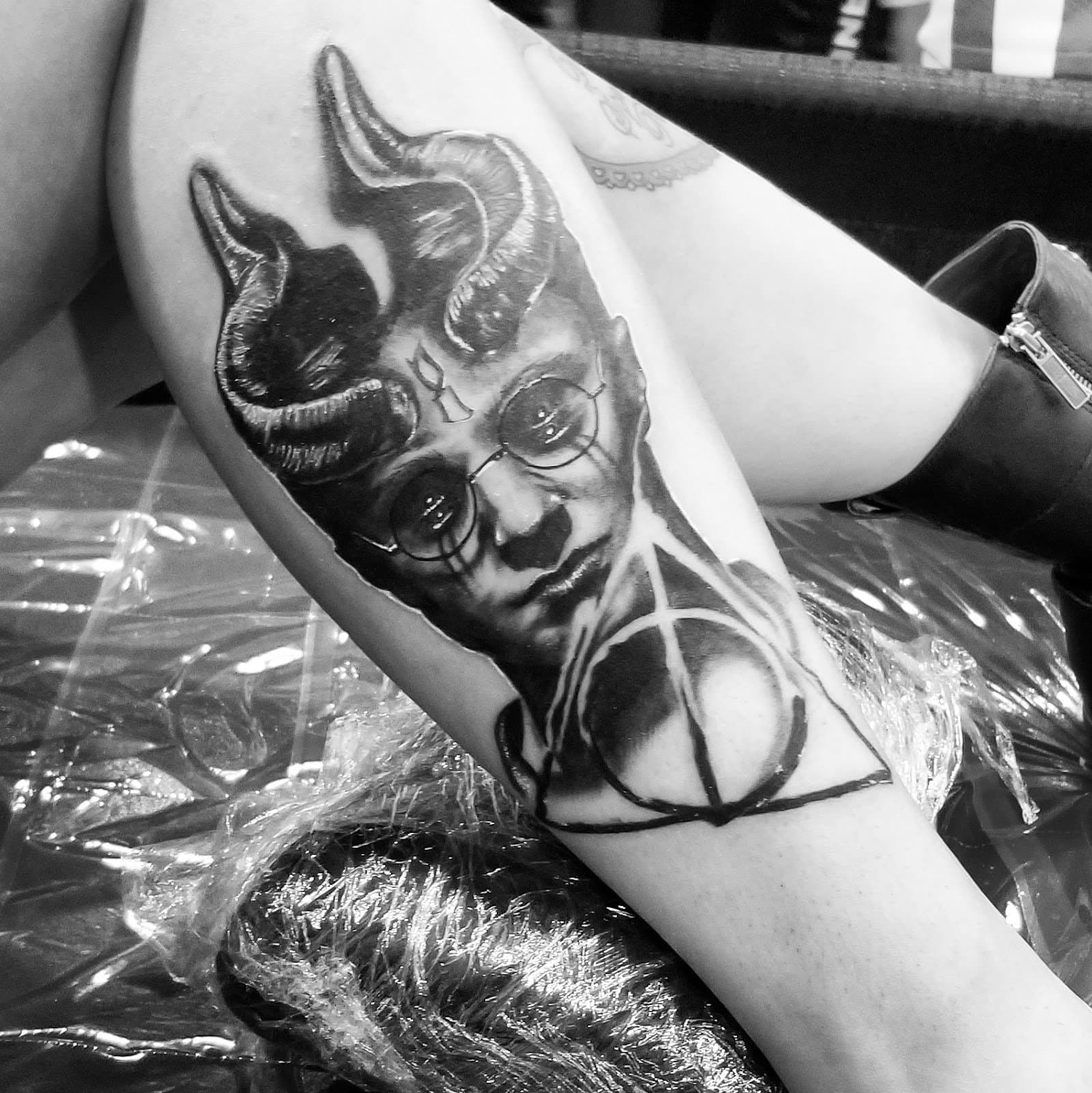 Black and grey horned portrait on a thigh