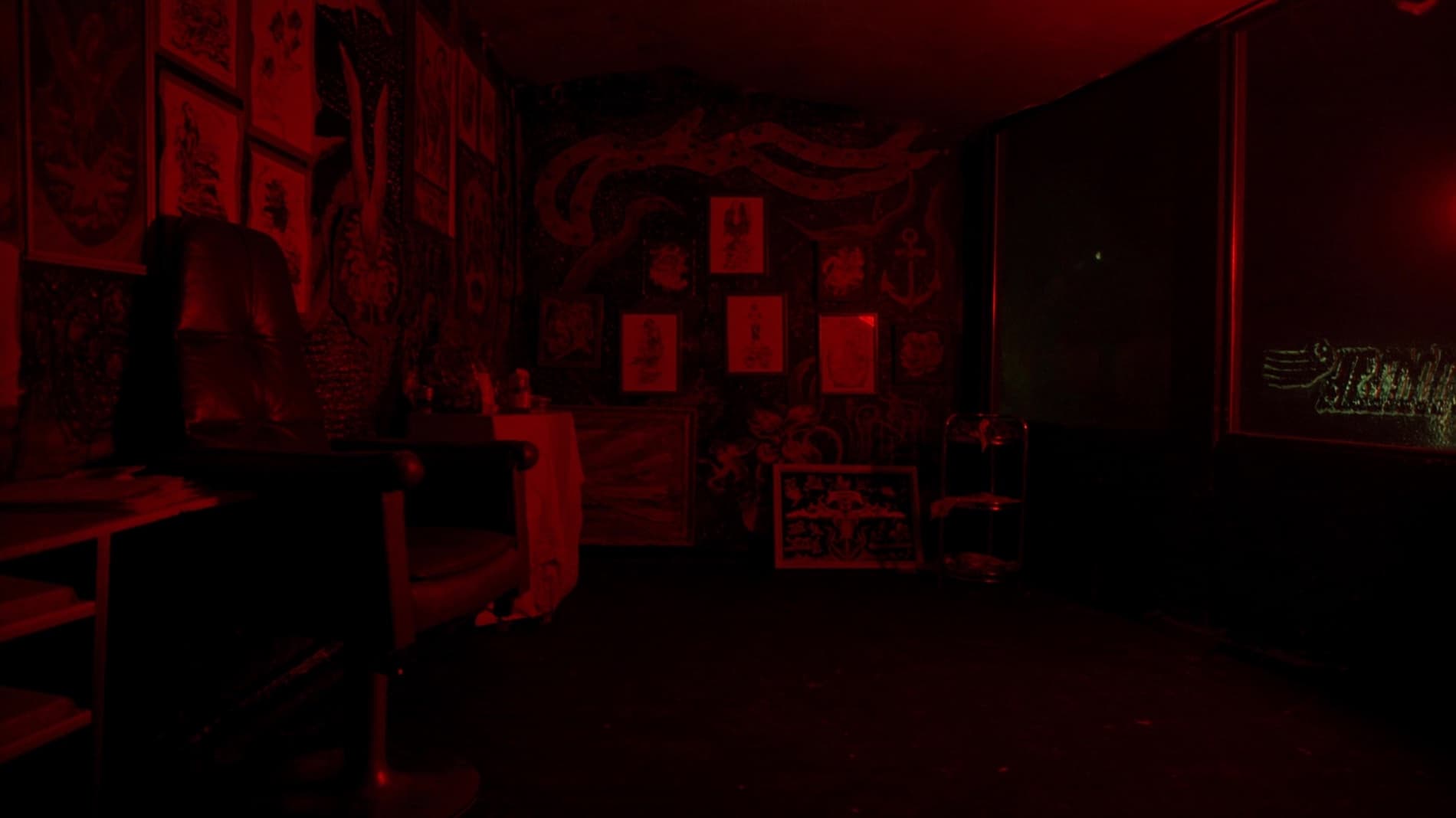 Old-school tattoo parlor wall covered in American traditional flash sheets under red neon glow