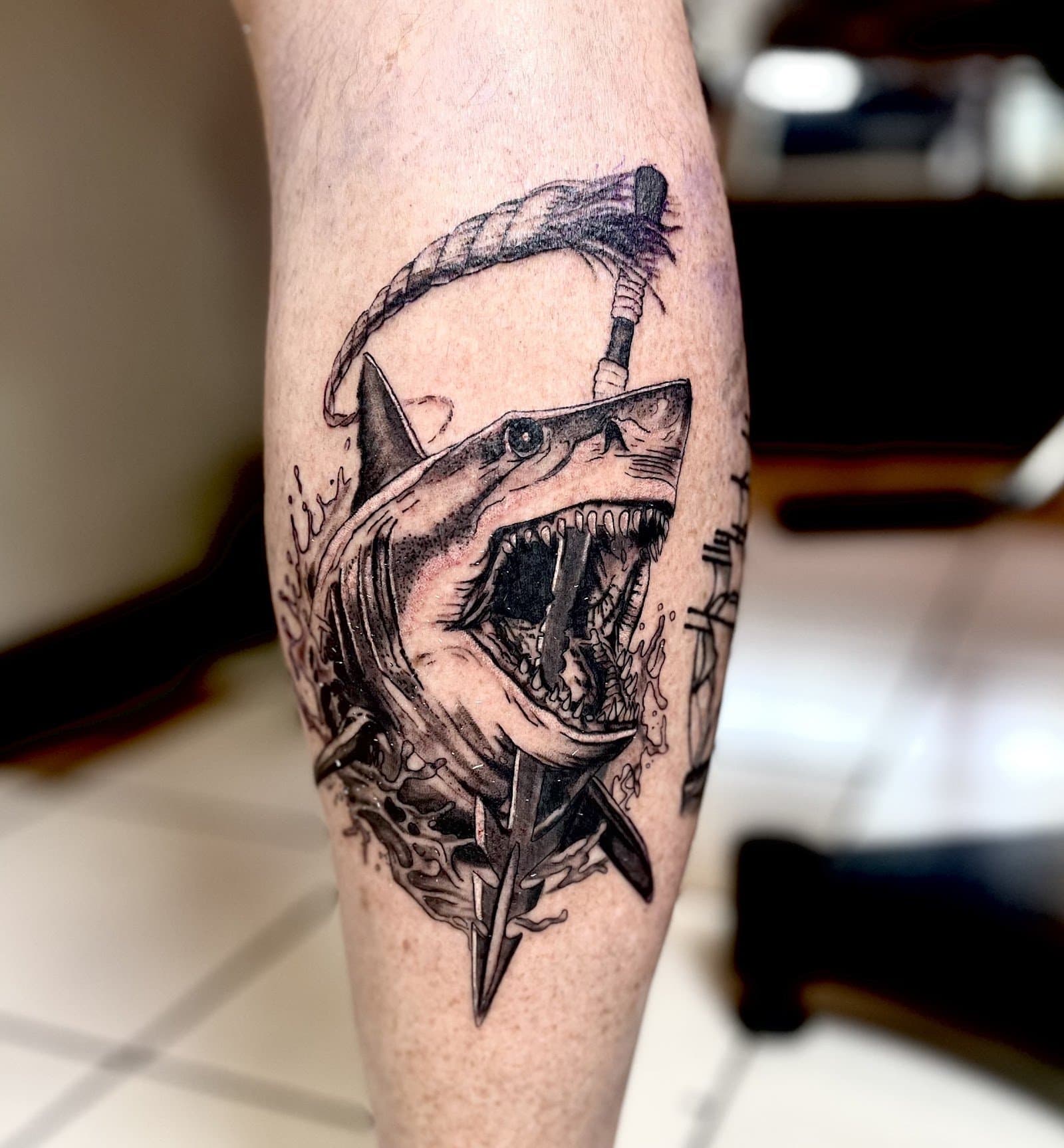 Black and grey shark leg tattoo