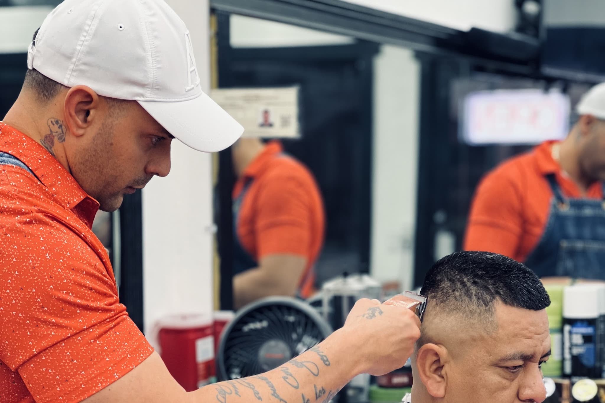 A barber at Marah BarberShop running clippers through a client's fade