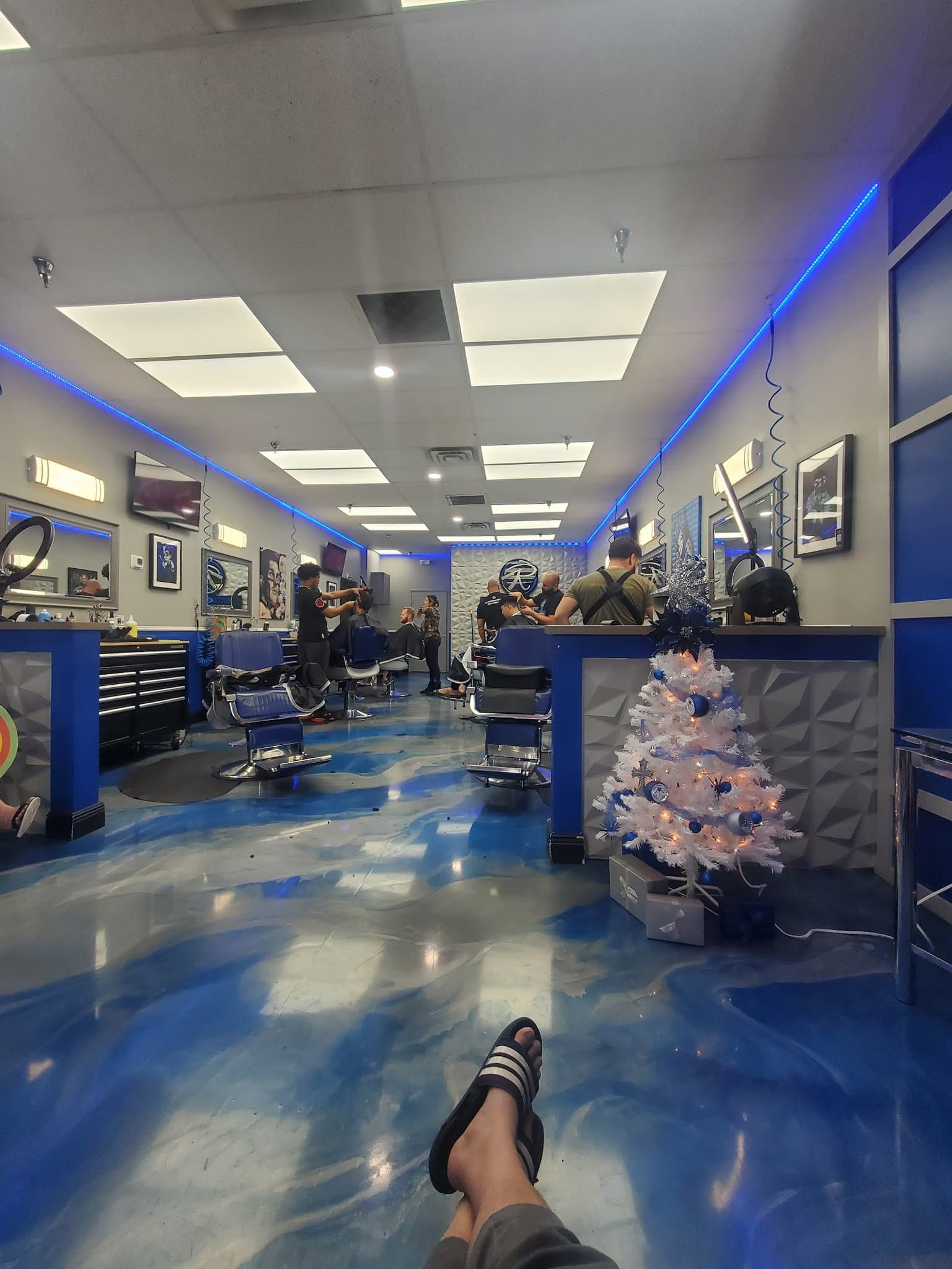 Inside Razorz Edge Barbershop — blue epoxy floor and busy chairs