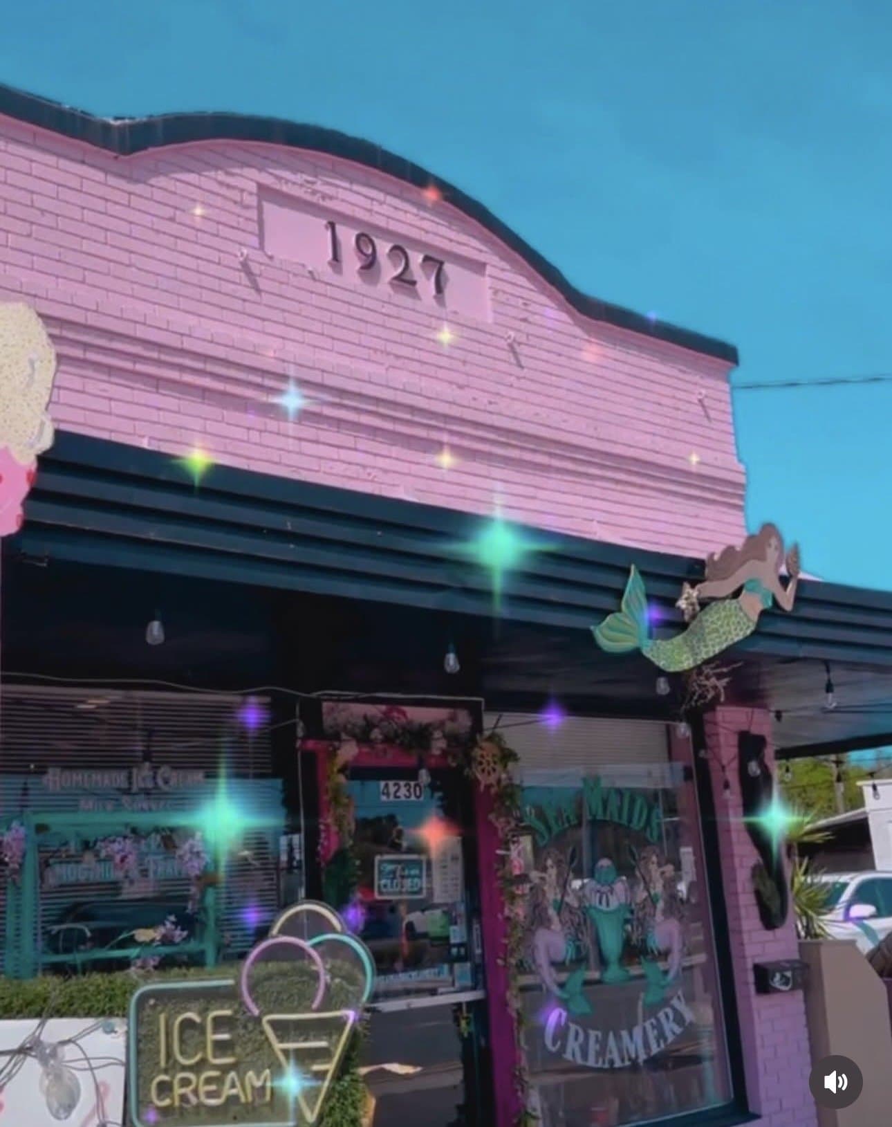 Sea Maids Creamery pink storefront with mermaid mural at dusk