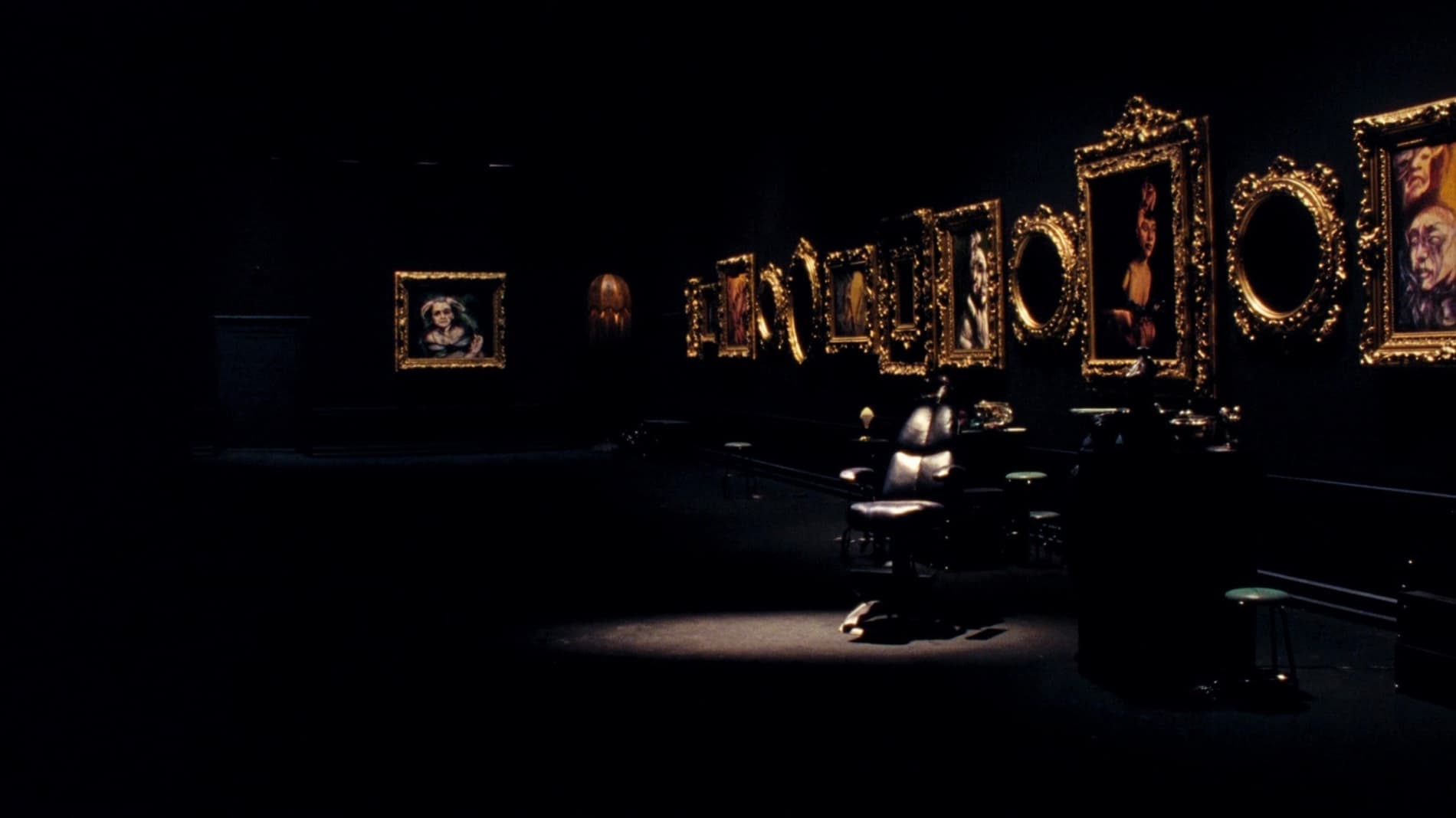 Gallery-style tattoo studio interior with gold-framed art under warm light