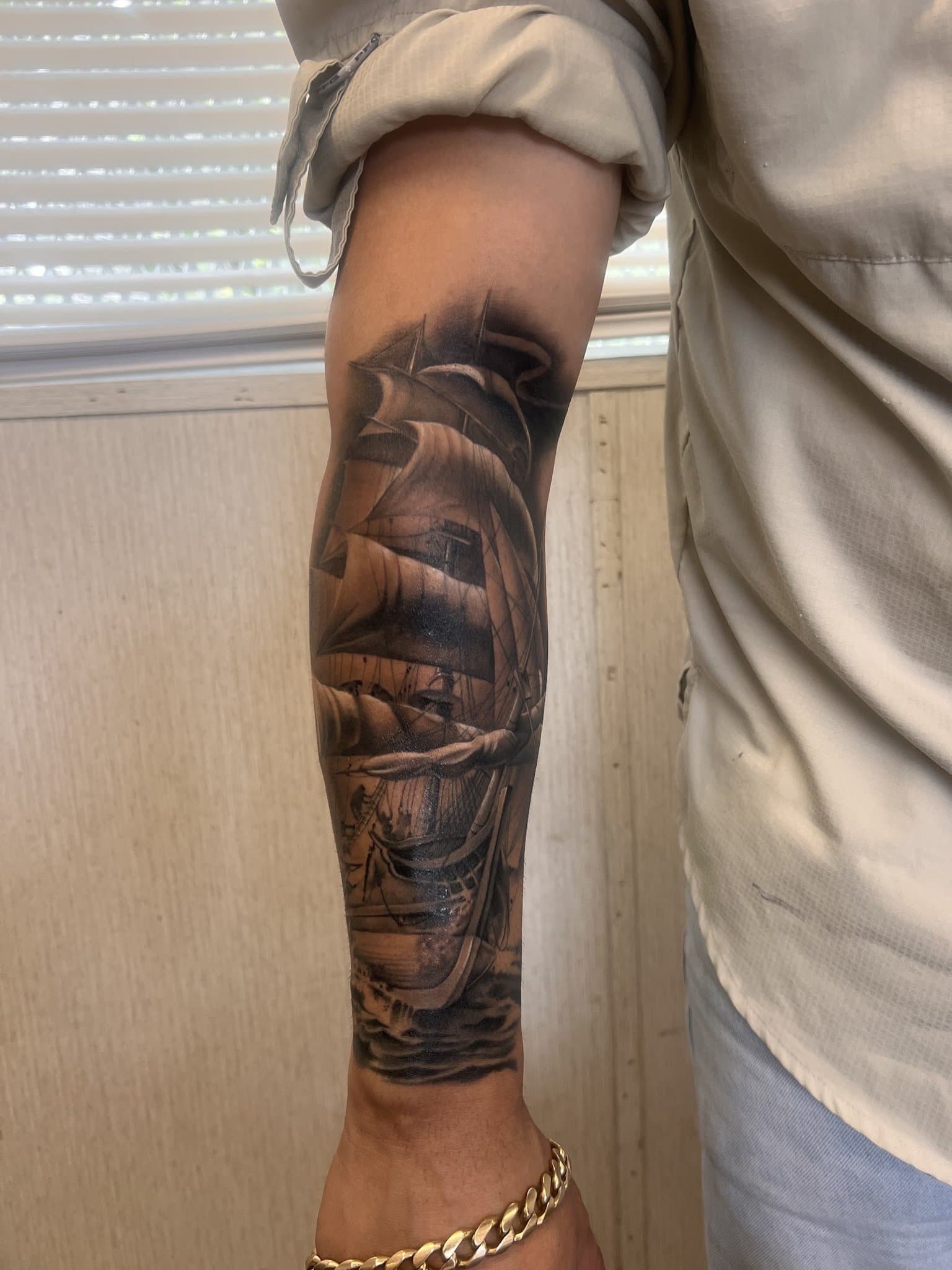Black and grey realism ship sleeve on a forearm