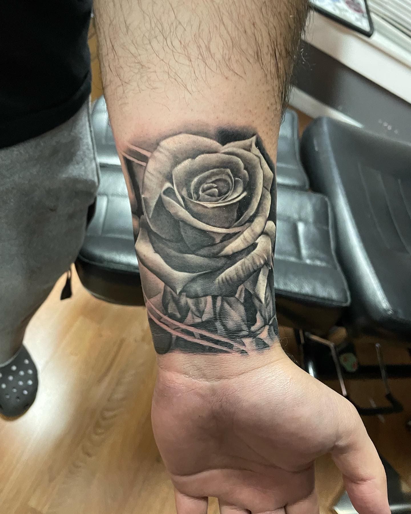 Black and grey rose tattoo on a wrist