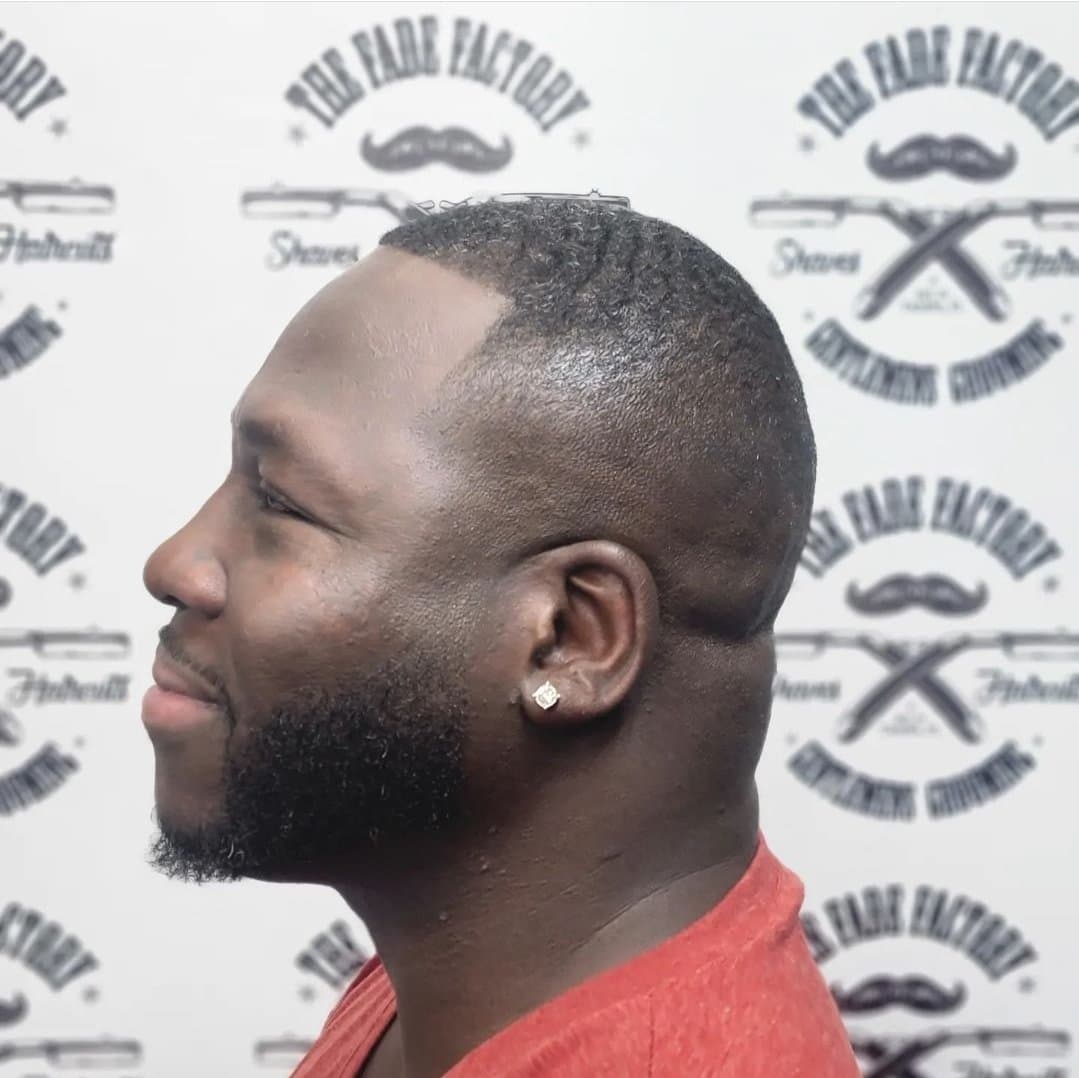 Crisp skin fade with sculpted beard at The Fade Factory