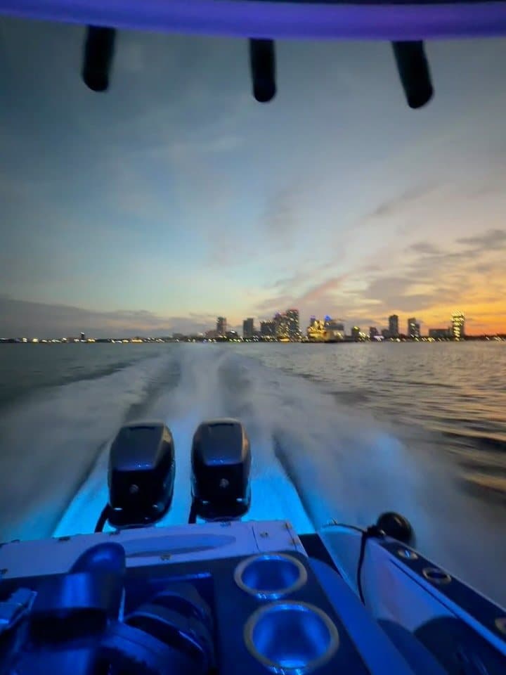 The view astern from the 35-foot Statement, wake trailing toward the Tampa skyline at sunset