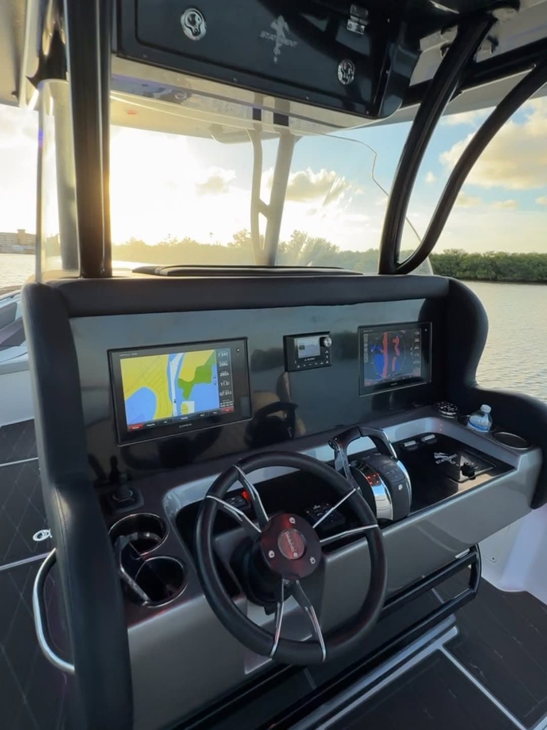 The helm of the 35-foot Statement at golden hour, twin displays and Mercury controls