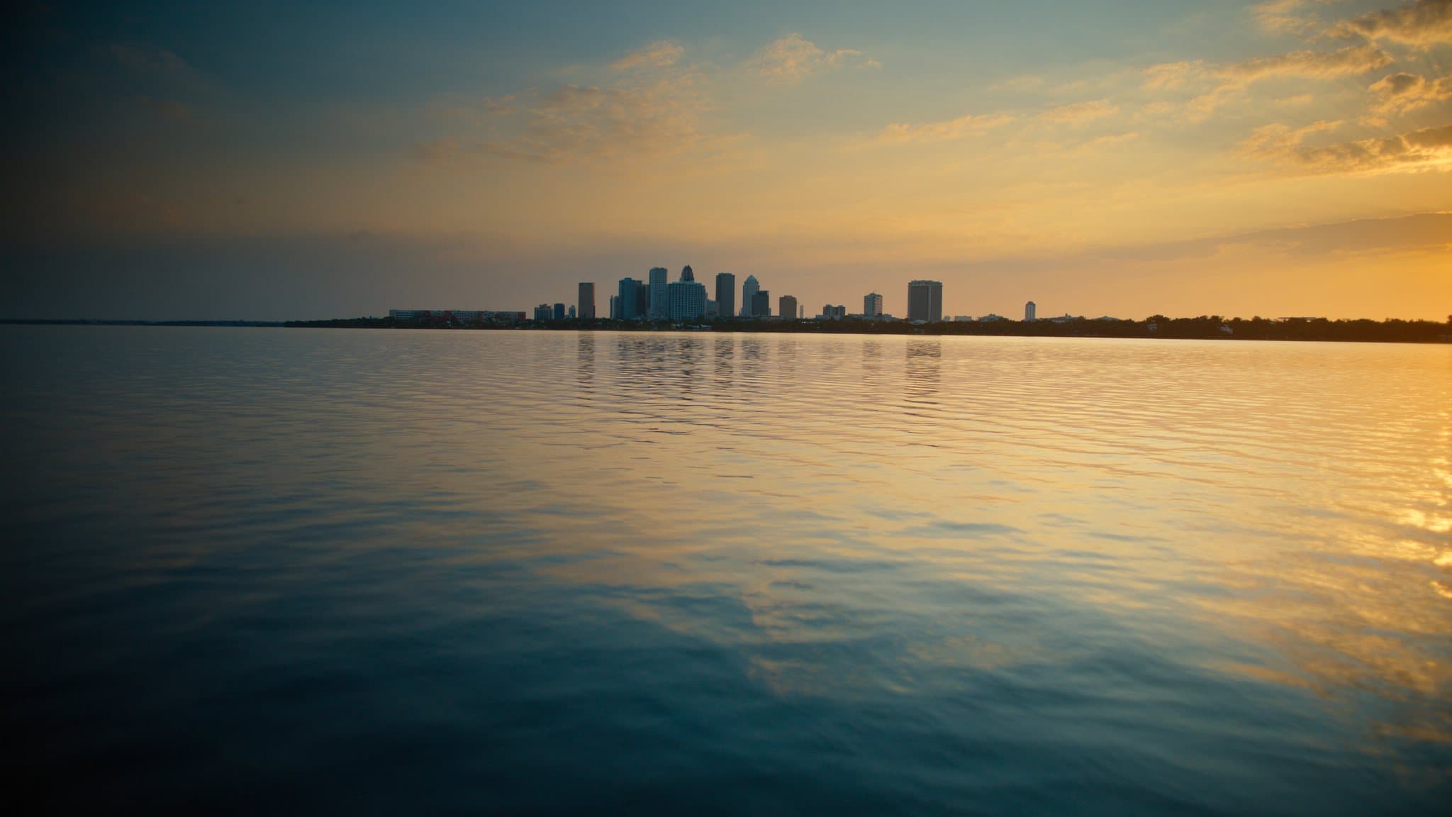 Tampa Bay at golden hour with the downtown Tampa skyline low on the horizon